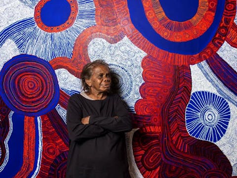 Betty Pumani Kuntiwa stands in front of her large scale painting