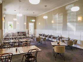 Interior view of Bushmanu2019s Arms Hotel's dining area with large windows and contemporary decor