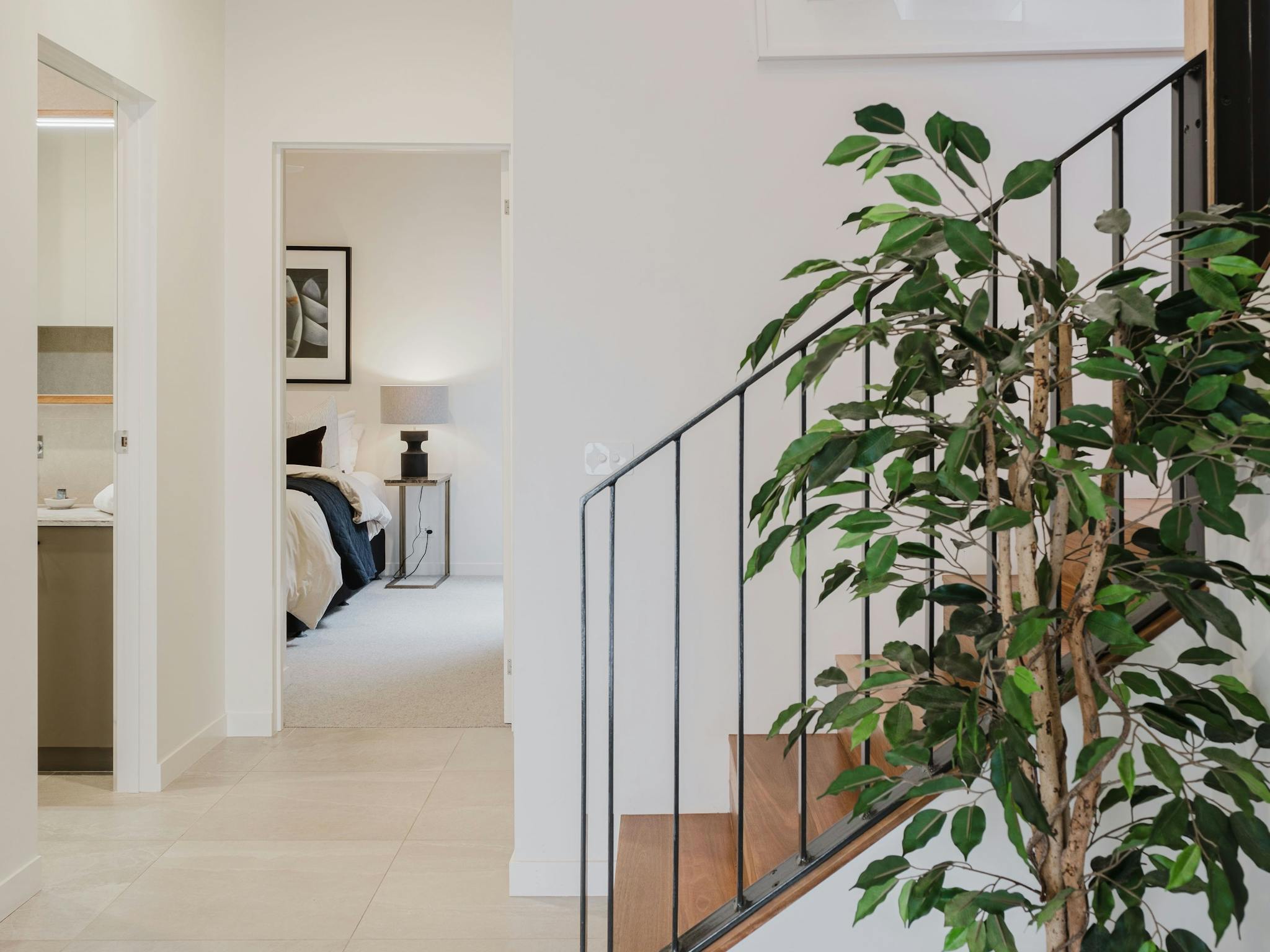 hallway with stairs and a plant next to it