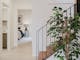 hallway with stairs and a plant next to it