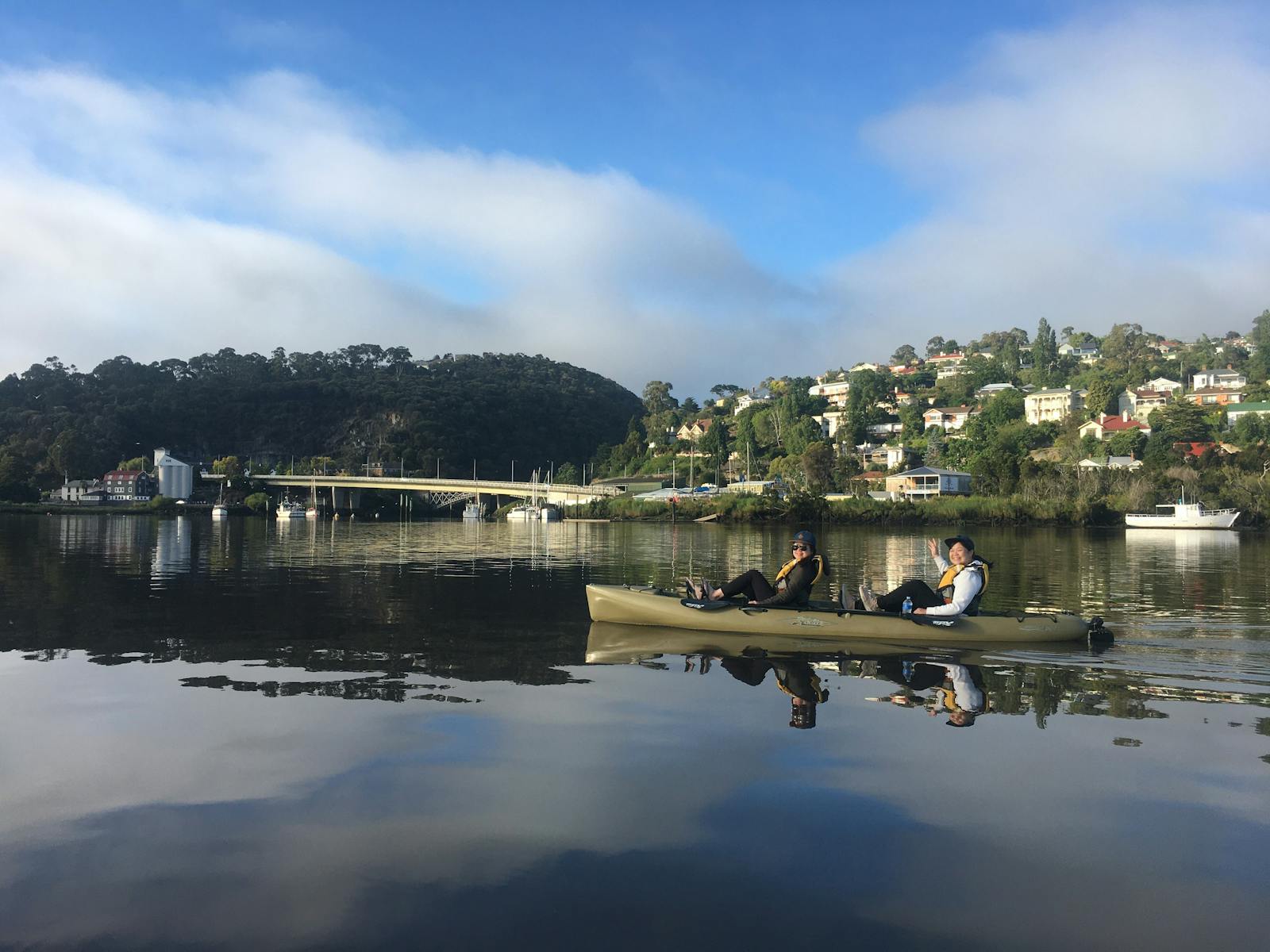 two people in a double pedal powered kayak on the Tamar river with reflections on the water