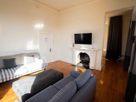 Lounge area in Matthews Suite. Includes sofa bed, gas fireplace & TV with streaming services access.