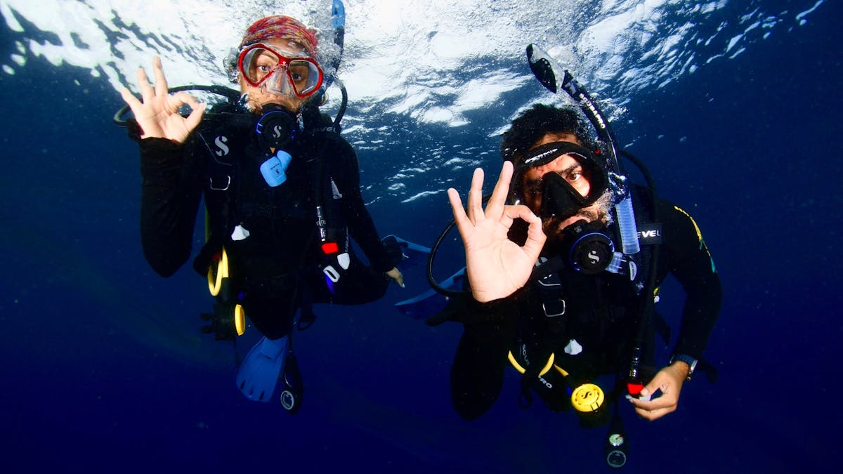 Scuba Diver signalling ok to their private guide photographer