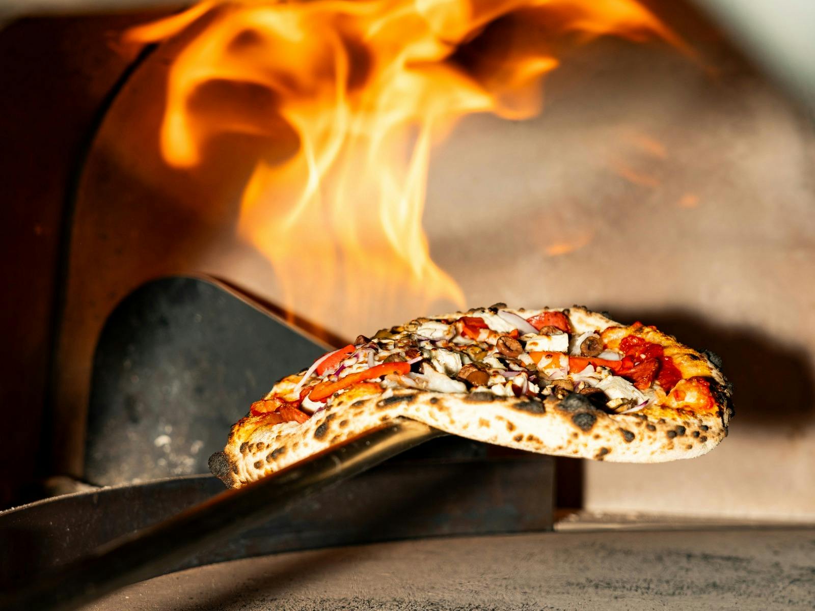 Pizza cooking in a wood-fired oven at Huskisson Hotel