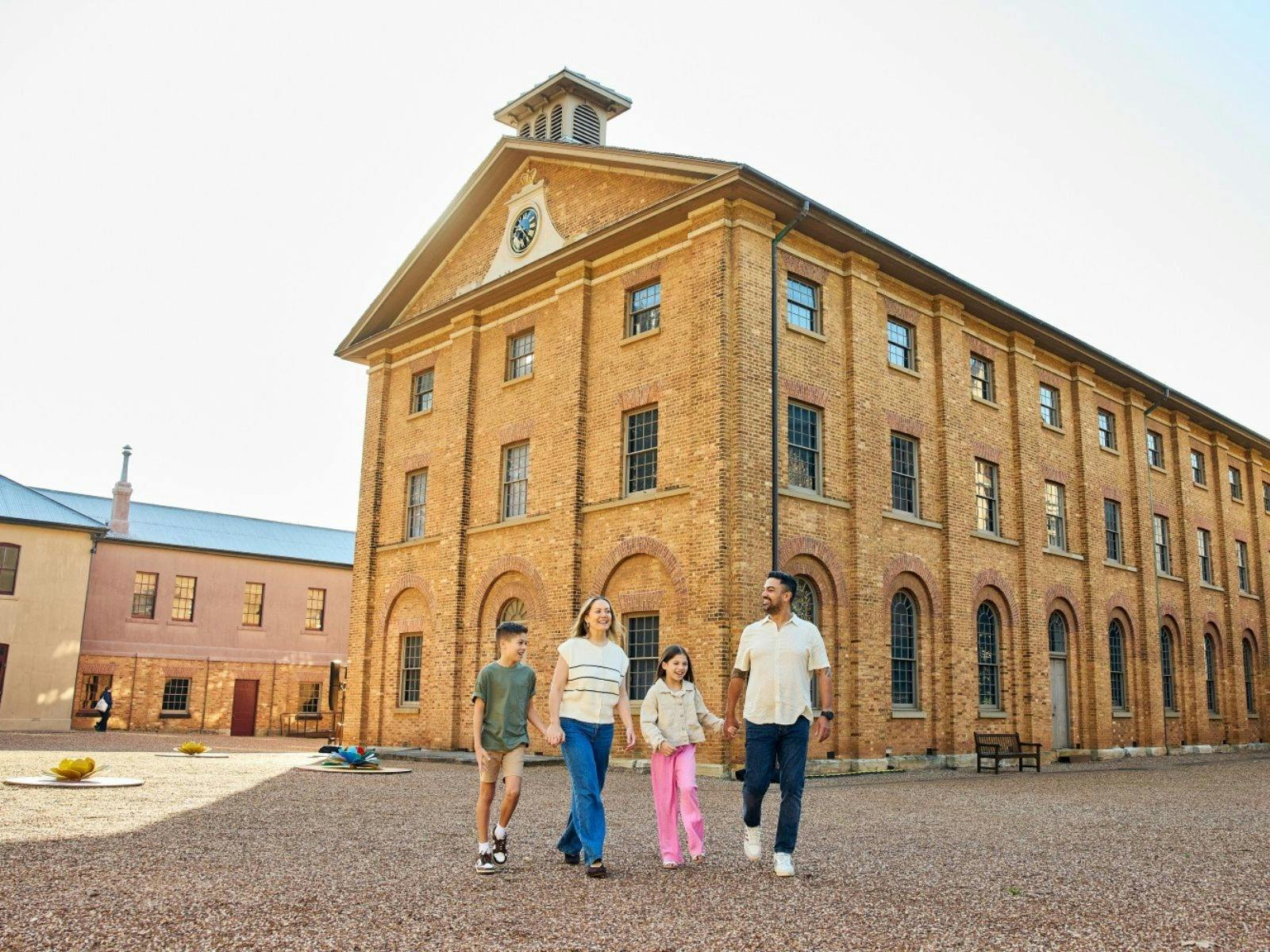 A family of four outside a sandstone building
