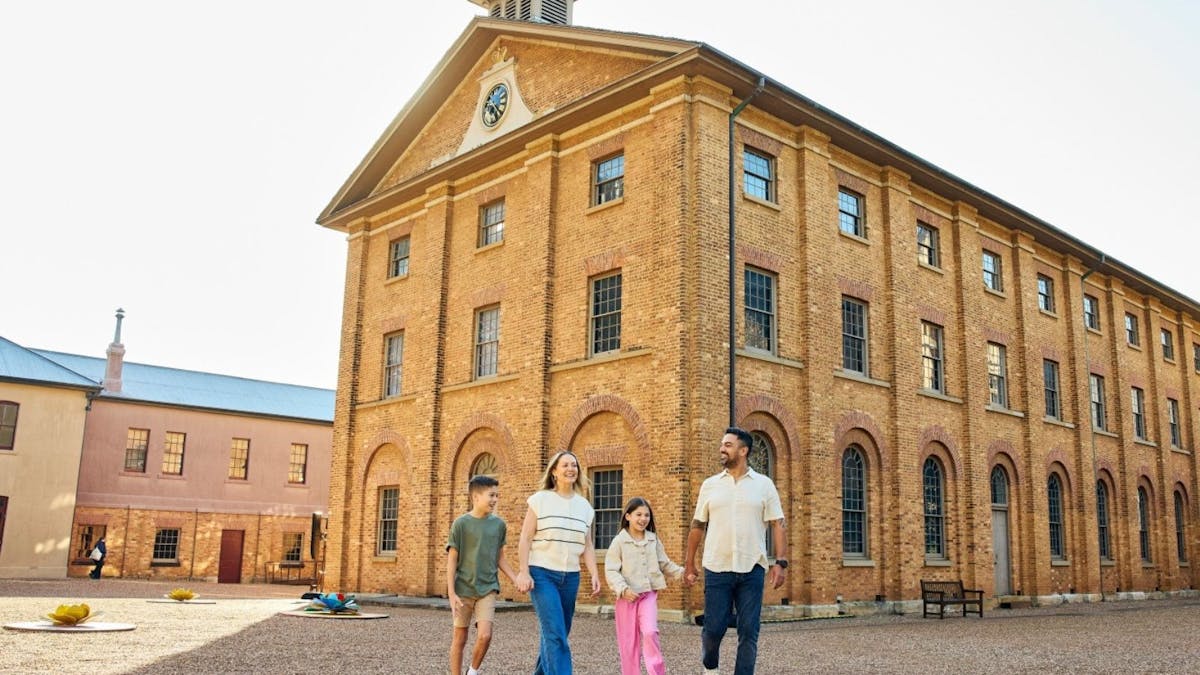A family of four outside a sandstone building