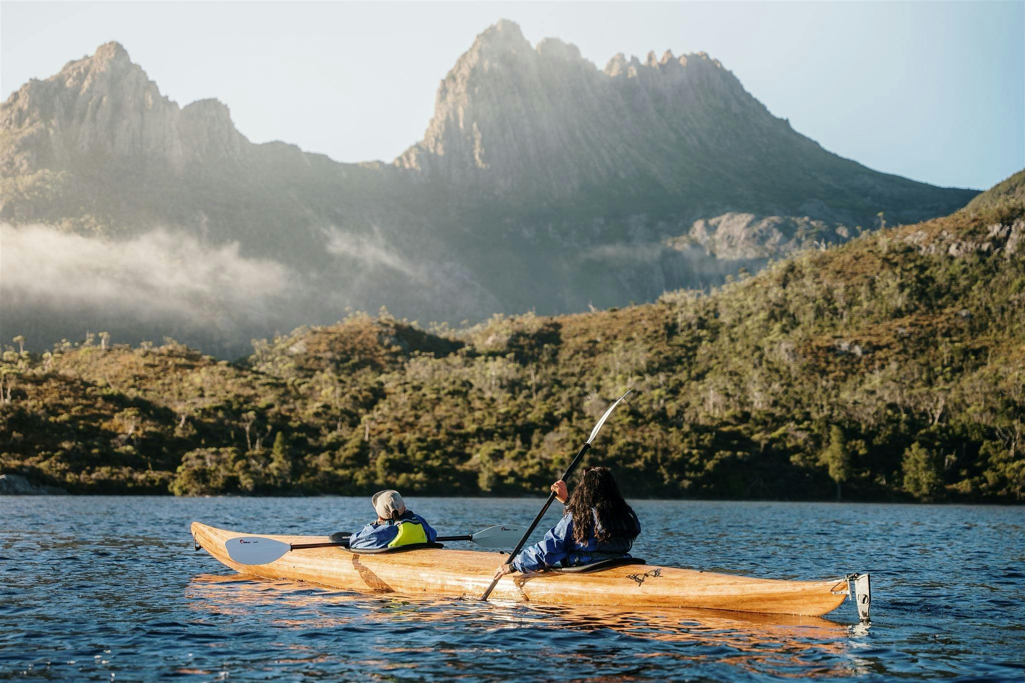 A mother and son paddling a two person timber kayak on Dove Lake