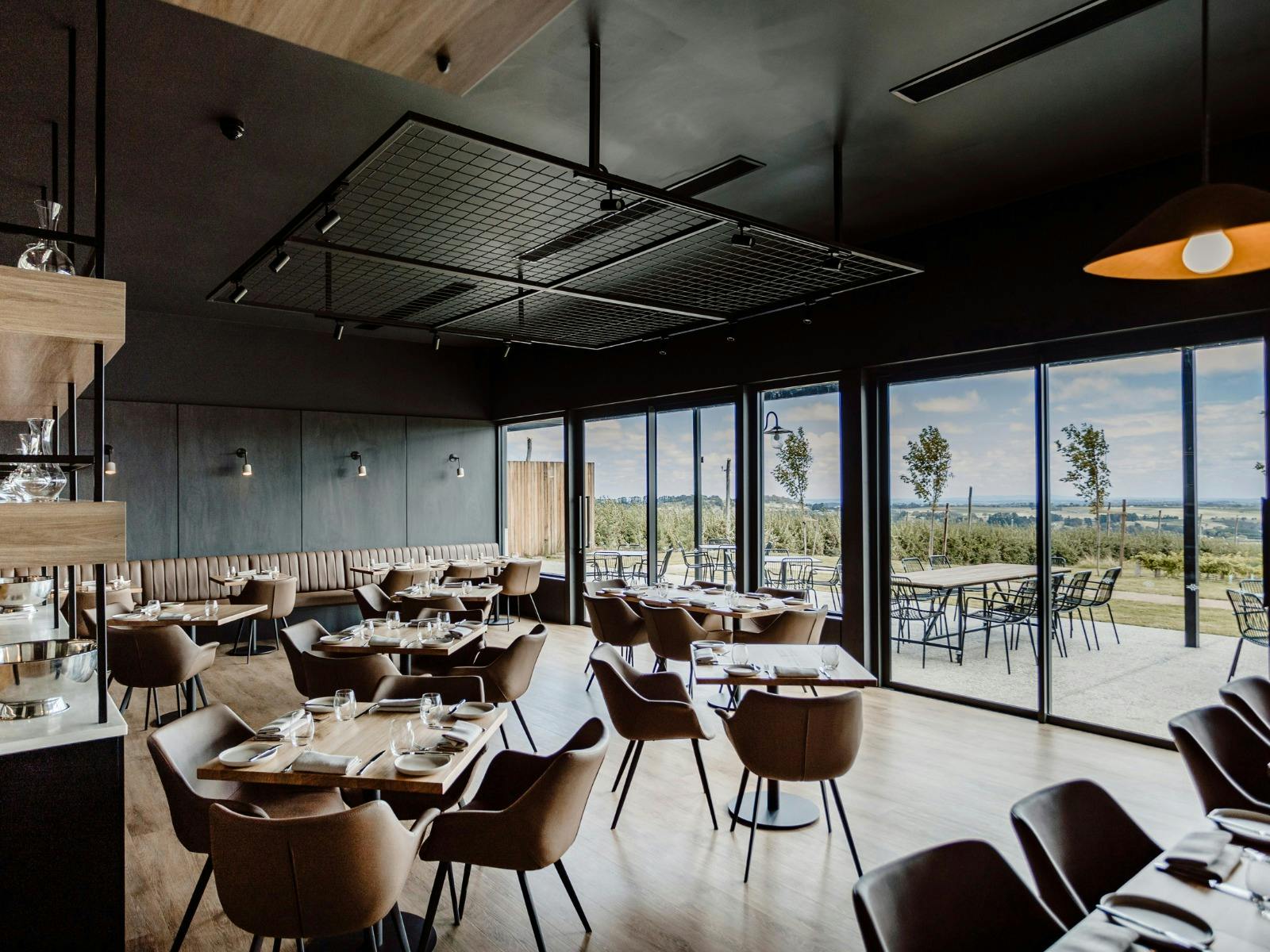 Printhie Dining restaurant with chairs and views outside showing apple orchard and vineyard