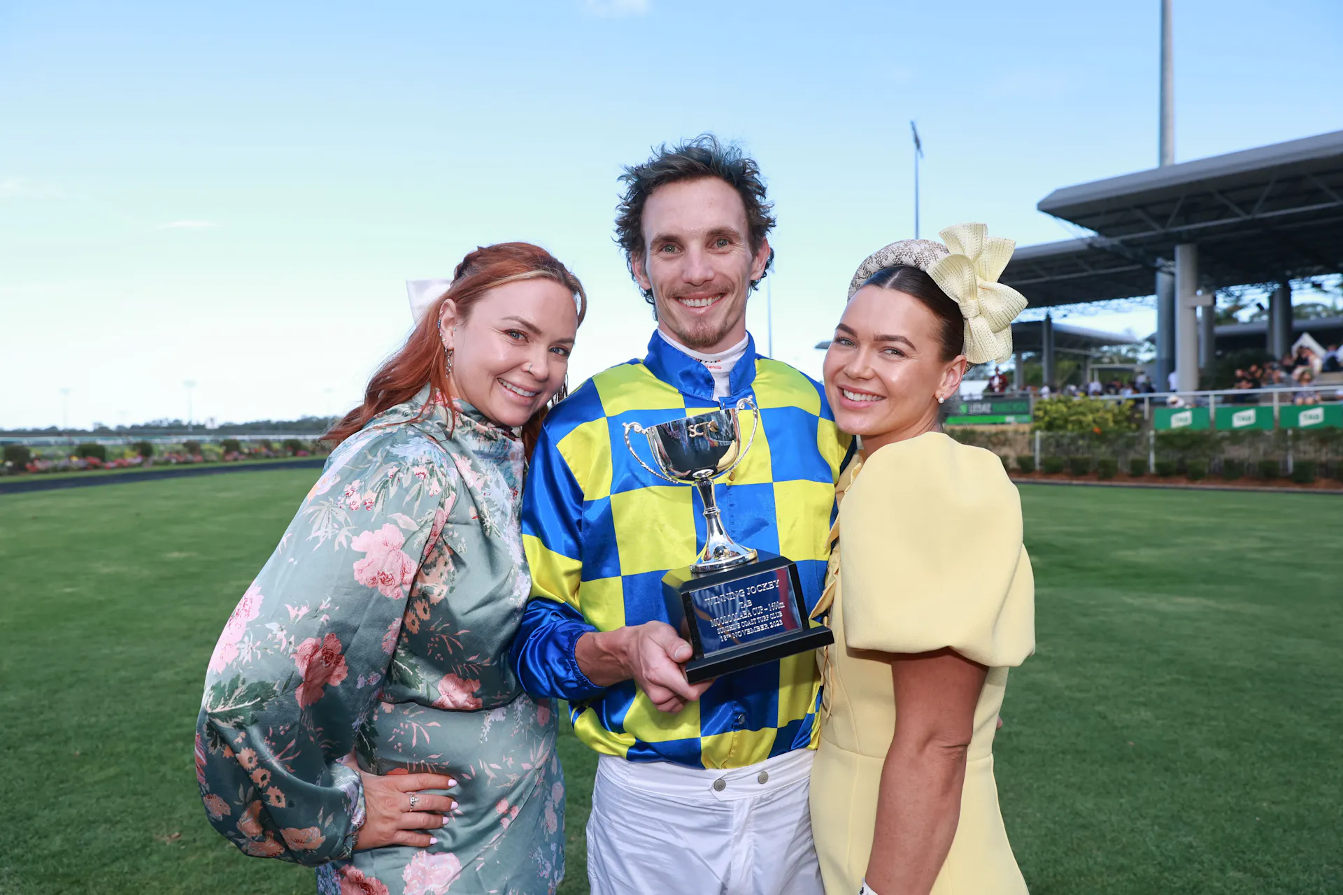 Jockey and Girls smiling and posing with trophies