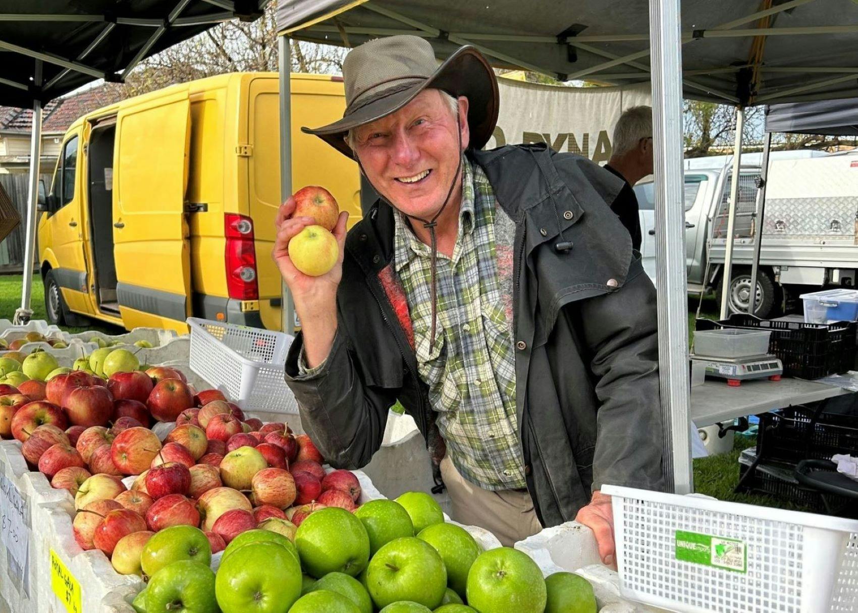 Farmer John holding an apple he has grown