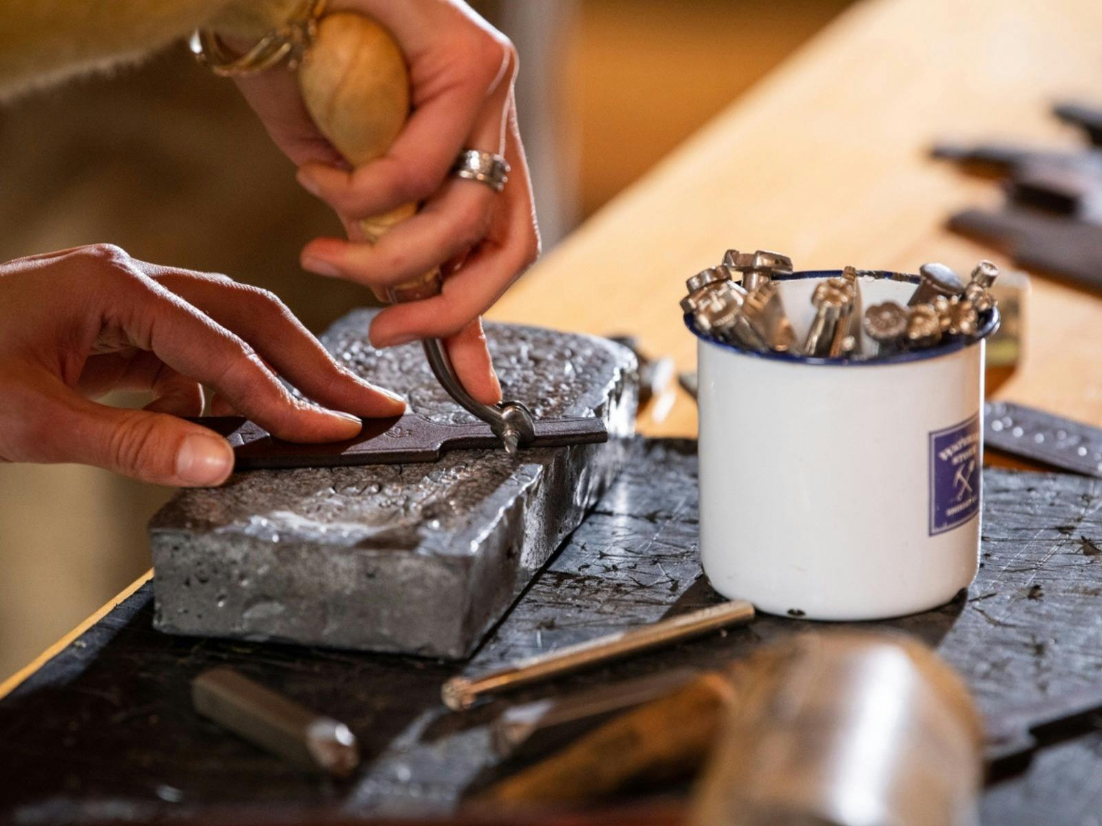 Close up of hands making leather keyring