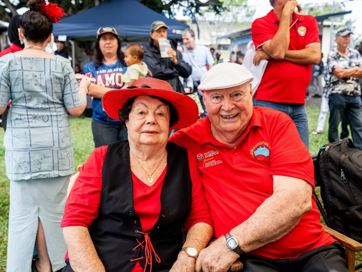 A man and woman in red pose for a photo whilst enjoying the Mareeba Multicultural Festival in FNQ.