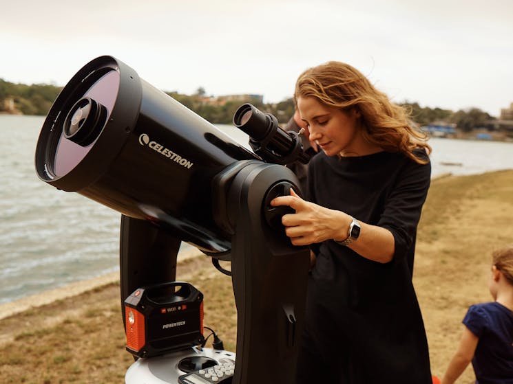 Woman using a telescope to look at the stars