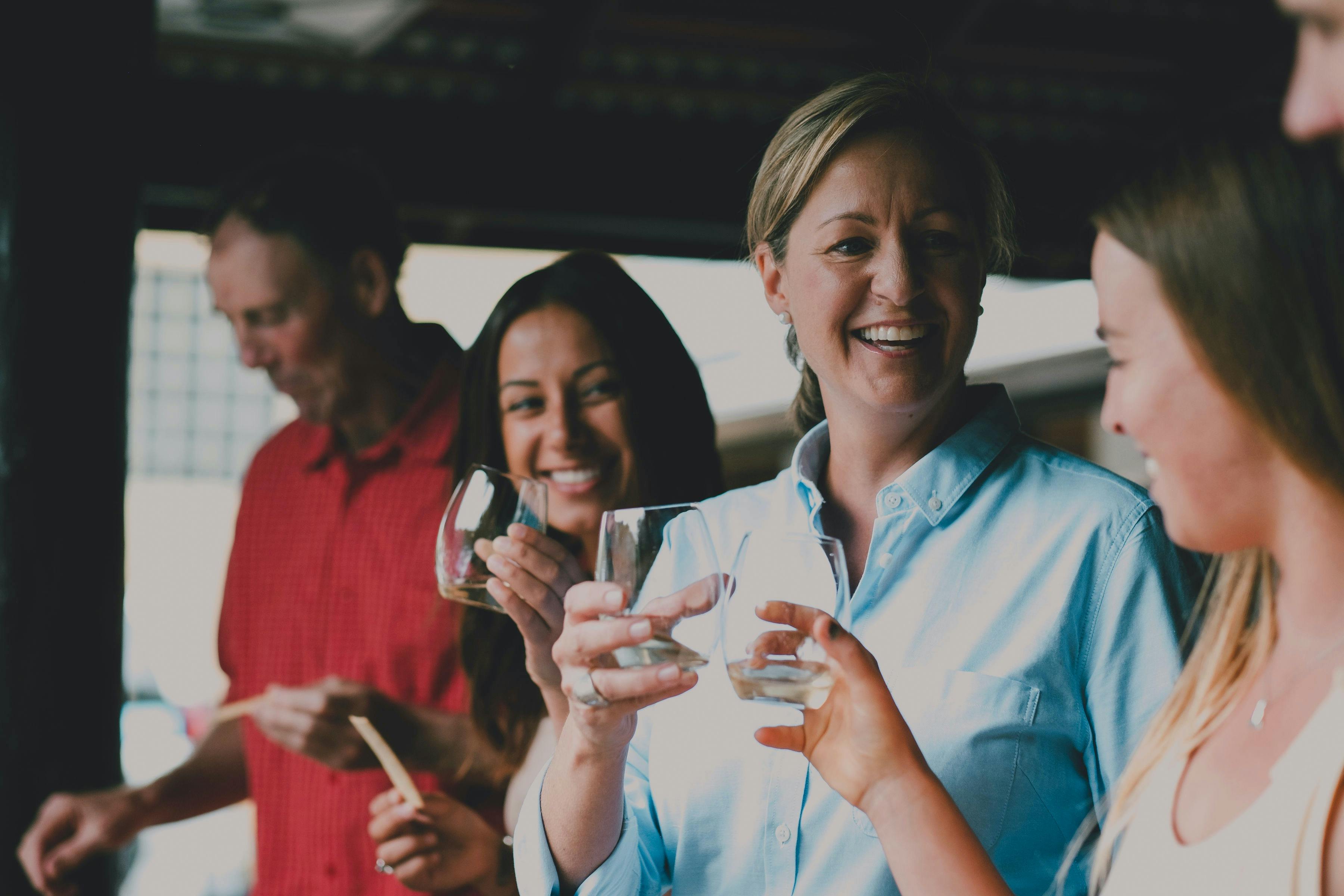 Host raises a glass of wine with guests