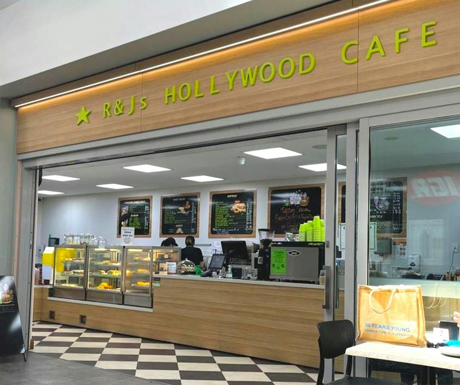 Front of cafe with menu boards and food display cases.