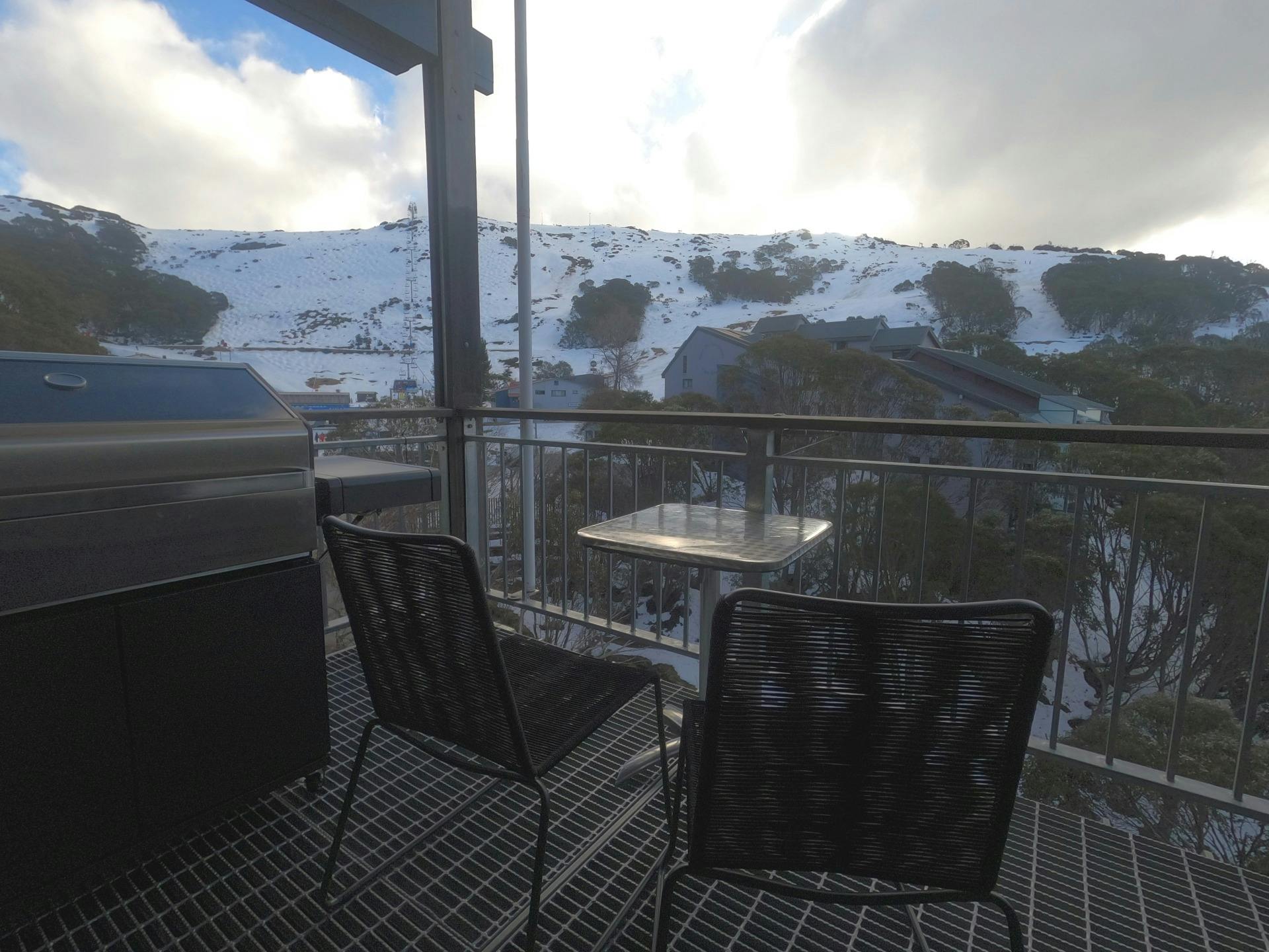 Balcony with barbecue and chairs