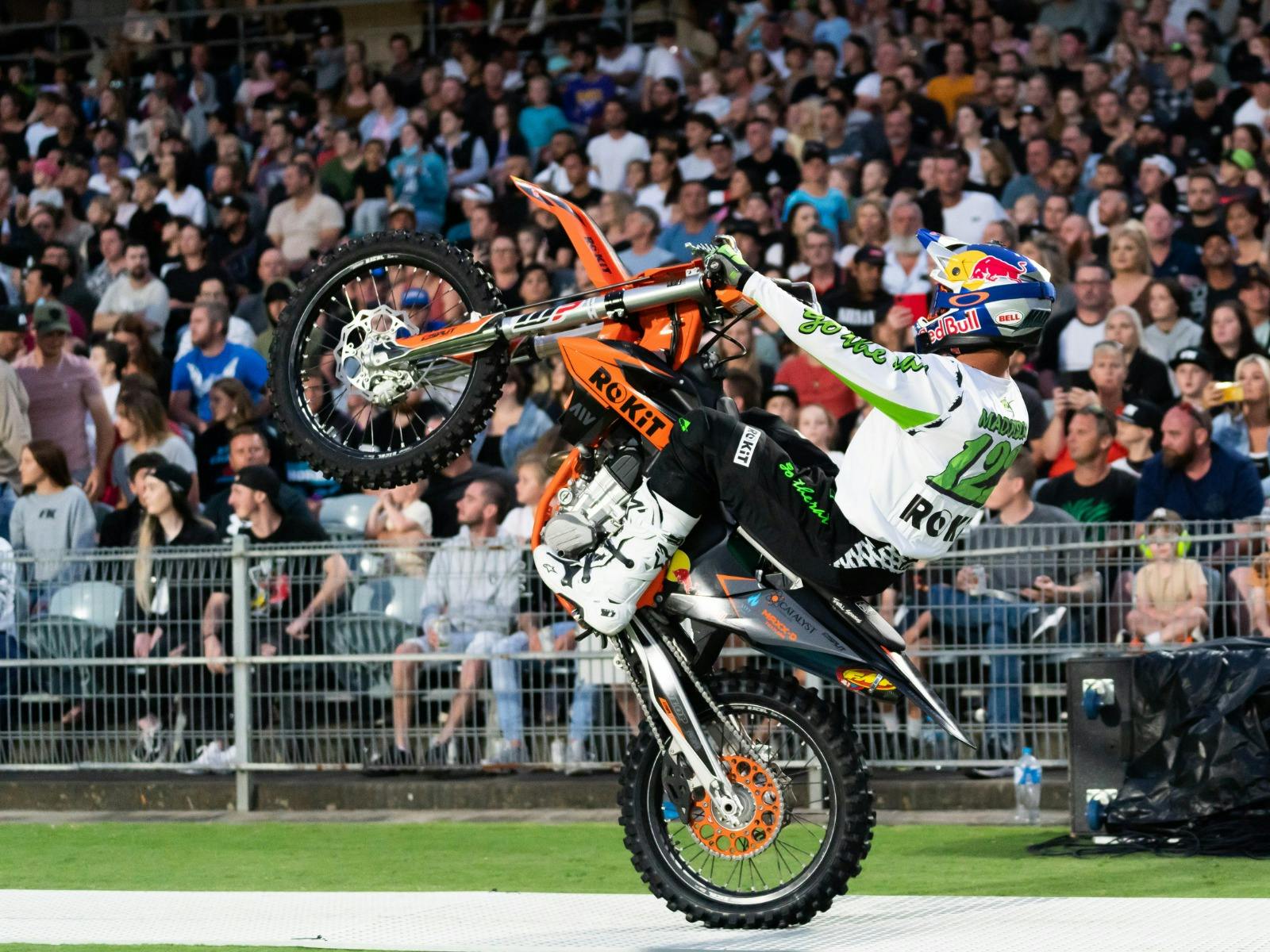 Rider performing trick in front of crowd.