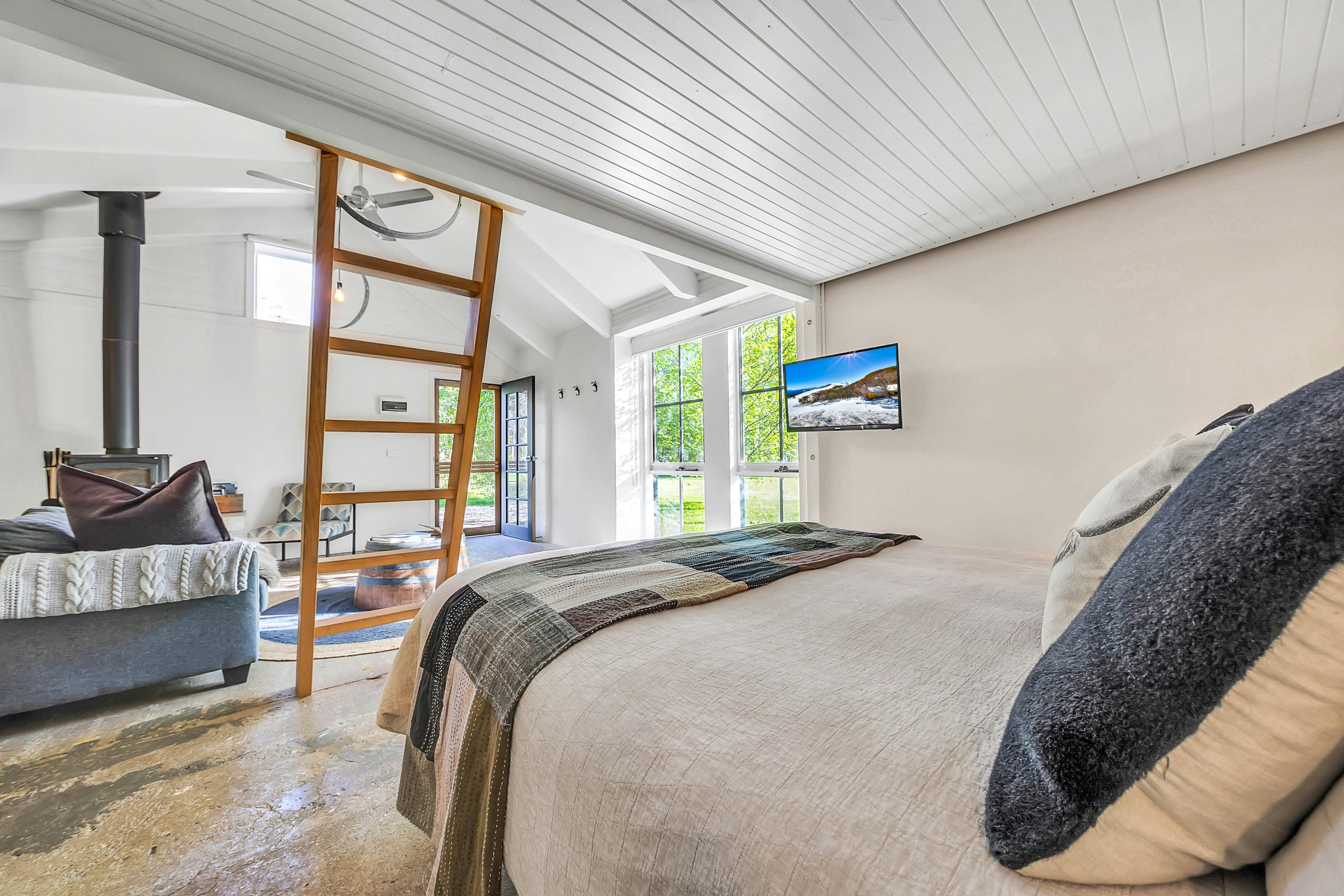 bedroom area with bed and television facing the lounge room