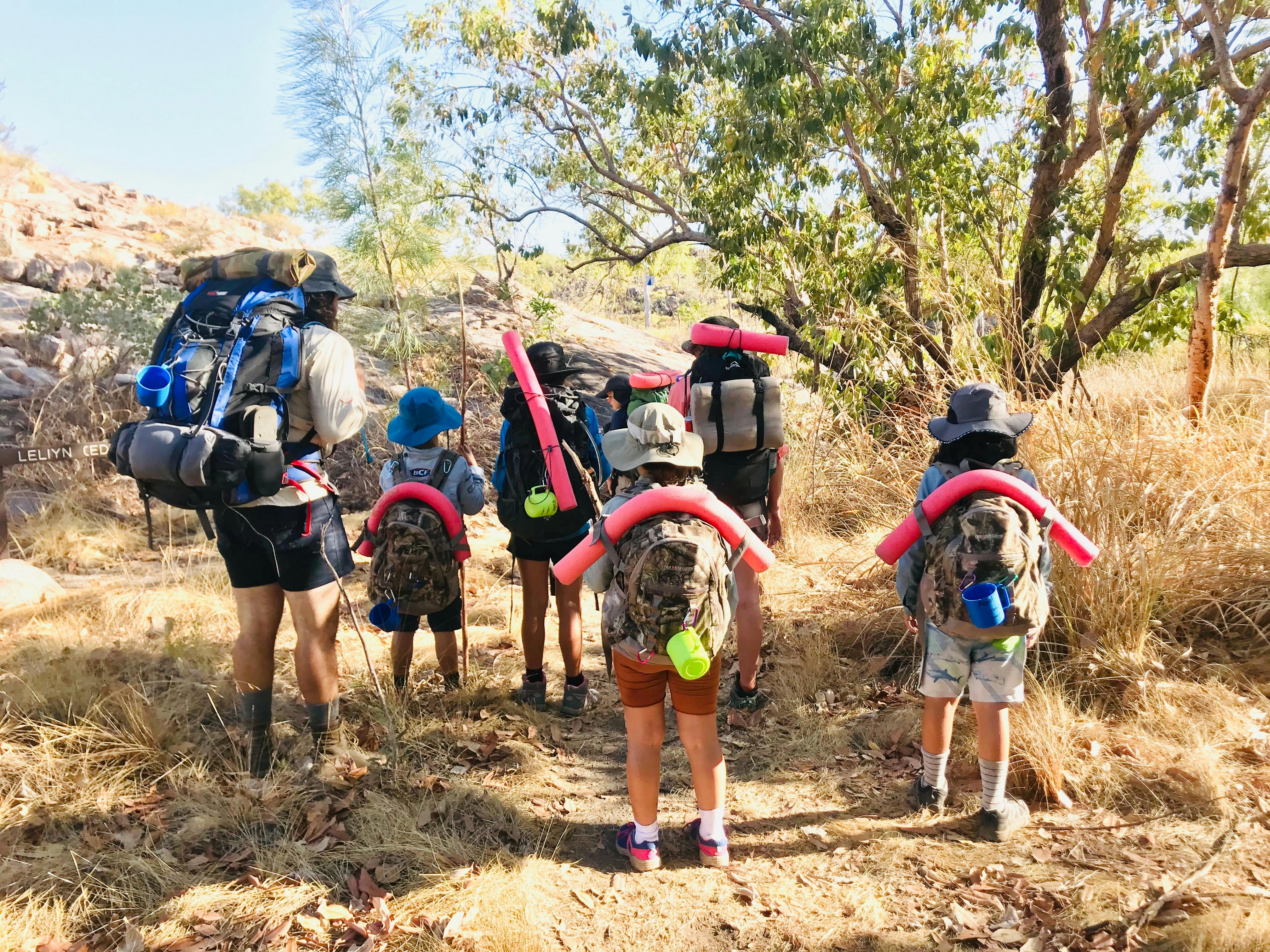 A group trekking with camping gear.