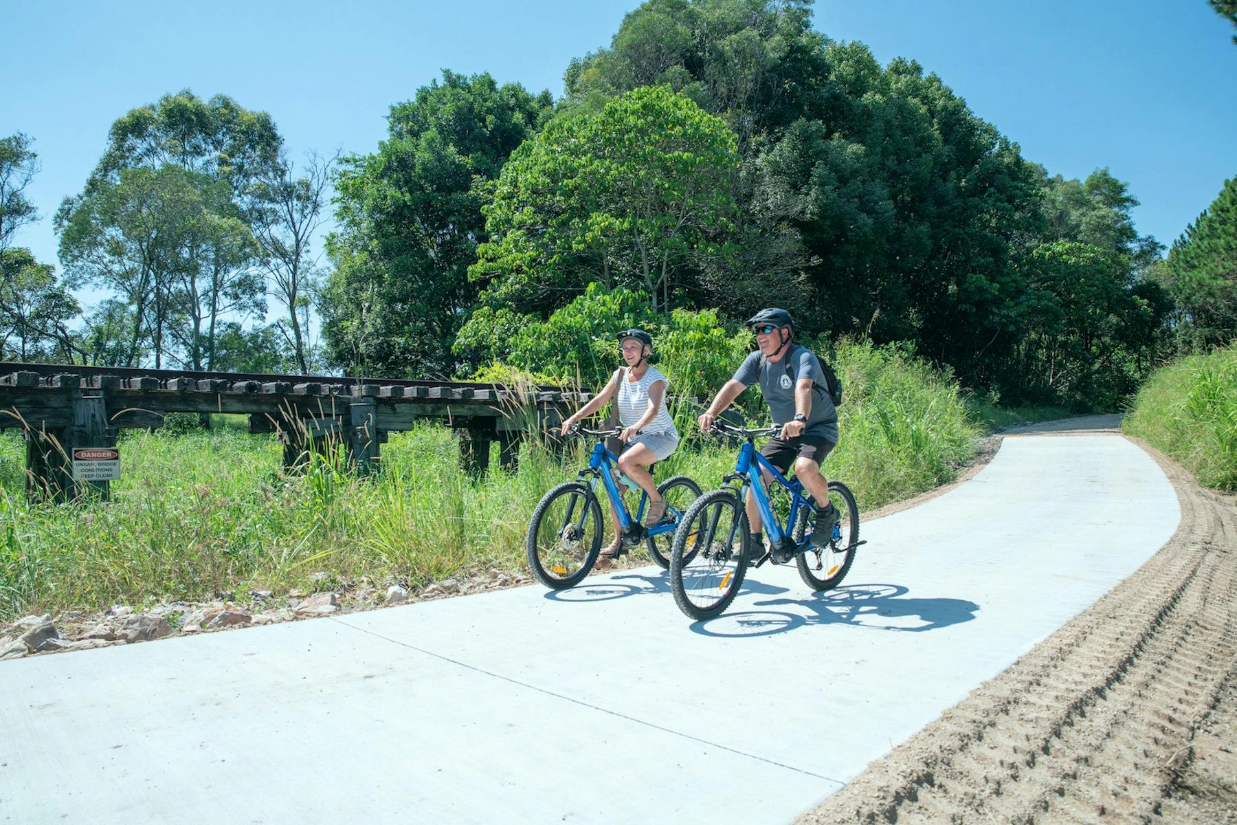 Two riders on ebikes on rail trail
