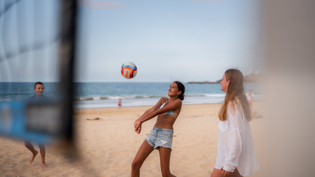 Shot of girls playing Volleyball on the beach outside Mooloolaba Holiday Park