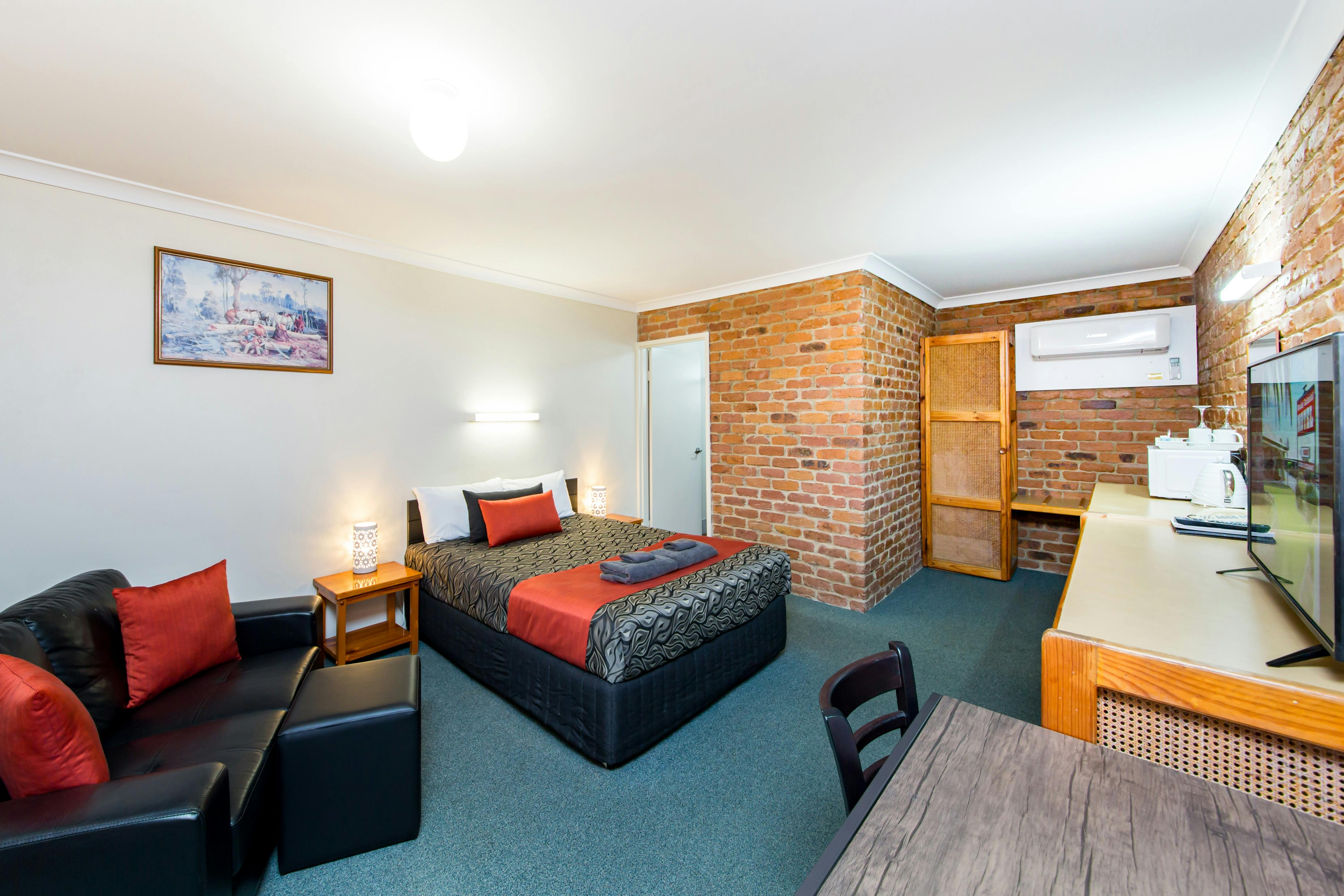 Spacious air-conditioned room with a comfortable queen bed, lounge, table & chairs, smart tv, kettle