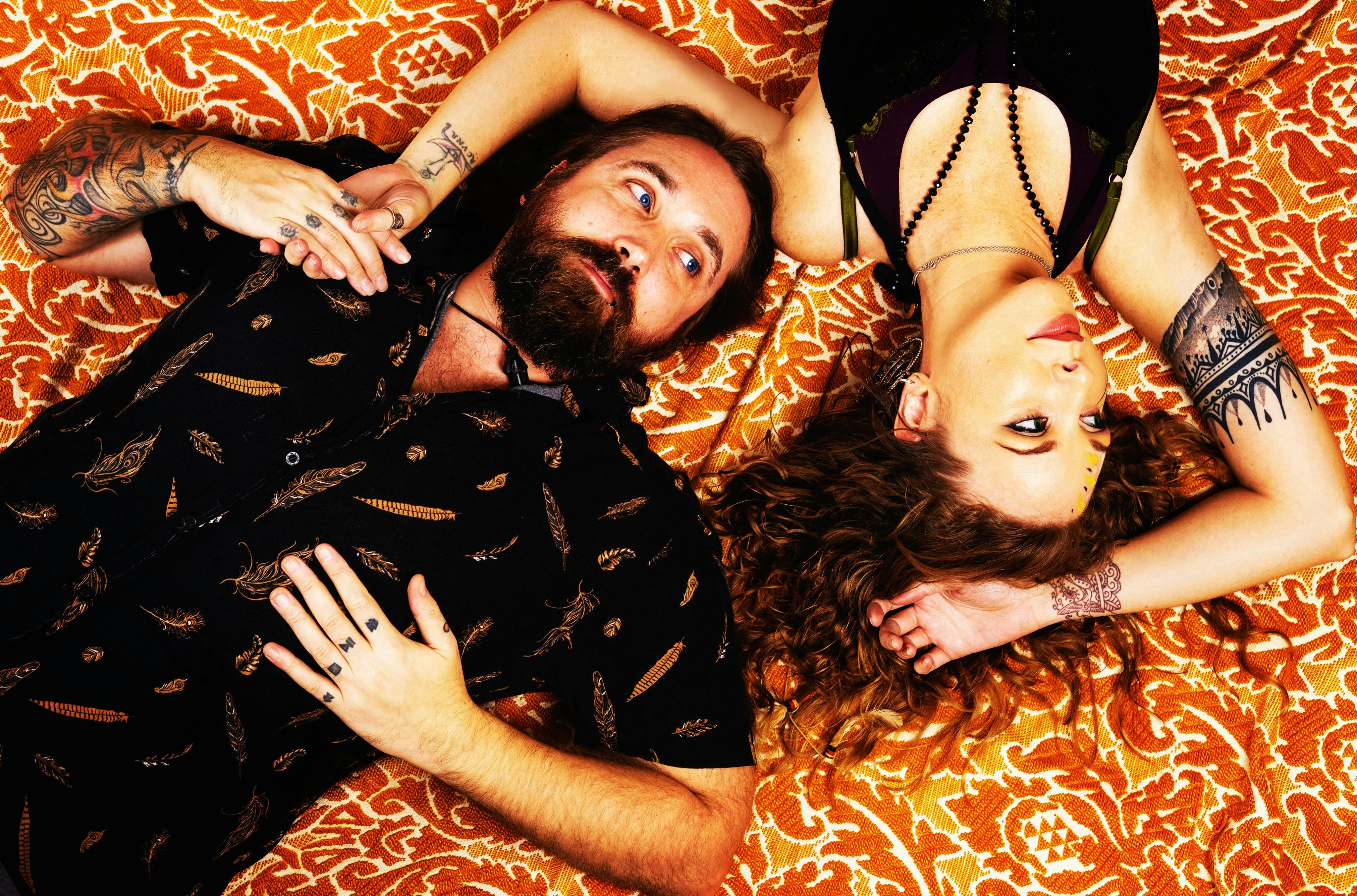 Two folks lie on a carpet