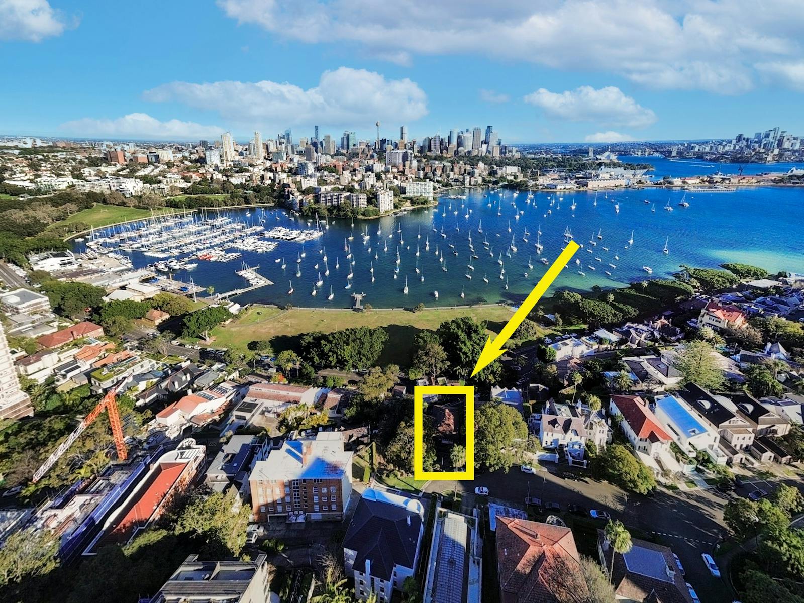 Aerial view of the property with surrounding cityscape and harbor in the distance.