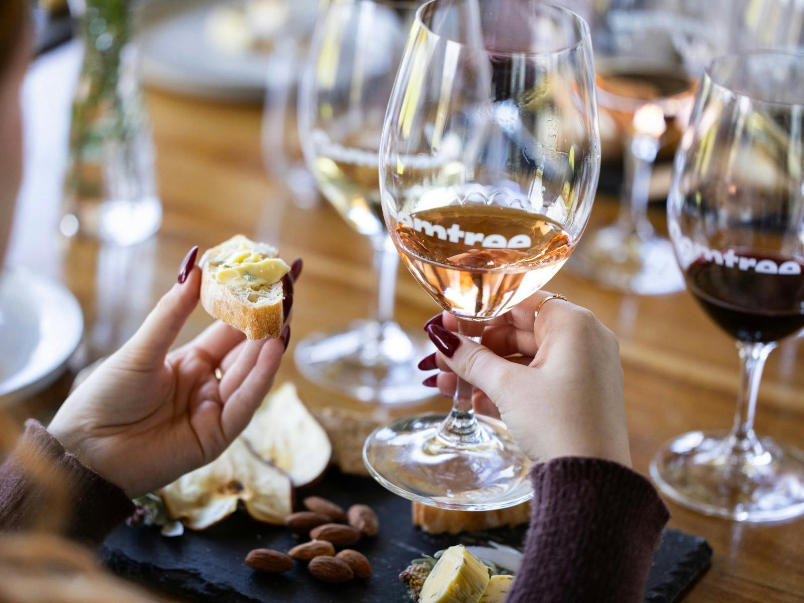 Woman's hand holding glass of wine and bread with butter