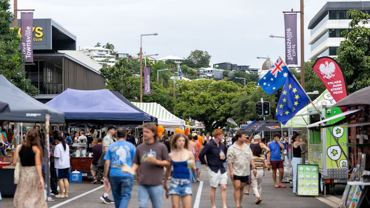 A lively crowd wandering through Cotters Market’s colourful stalls