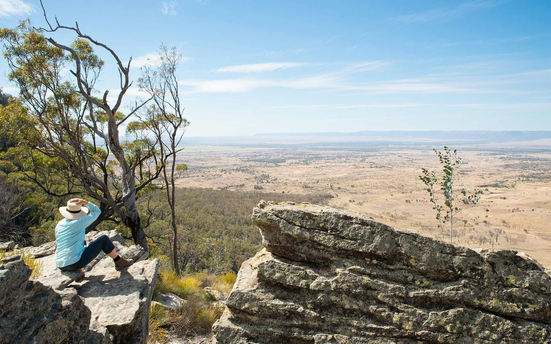 A Boobook Explore guest sitting on a rock edge, overlooking Arcadia Valley