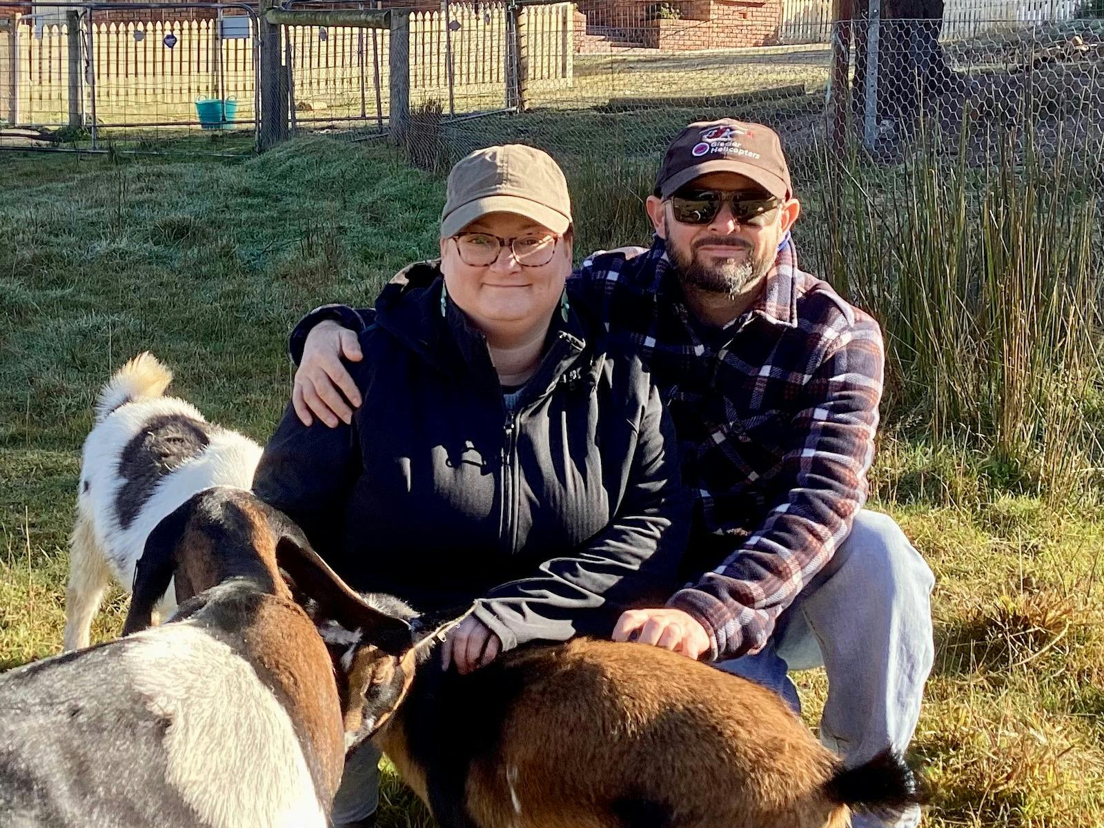 Couple patting goats