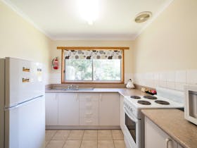 Kitchen fully equipped with stove and microwave