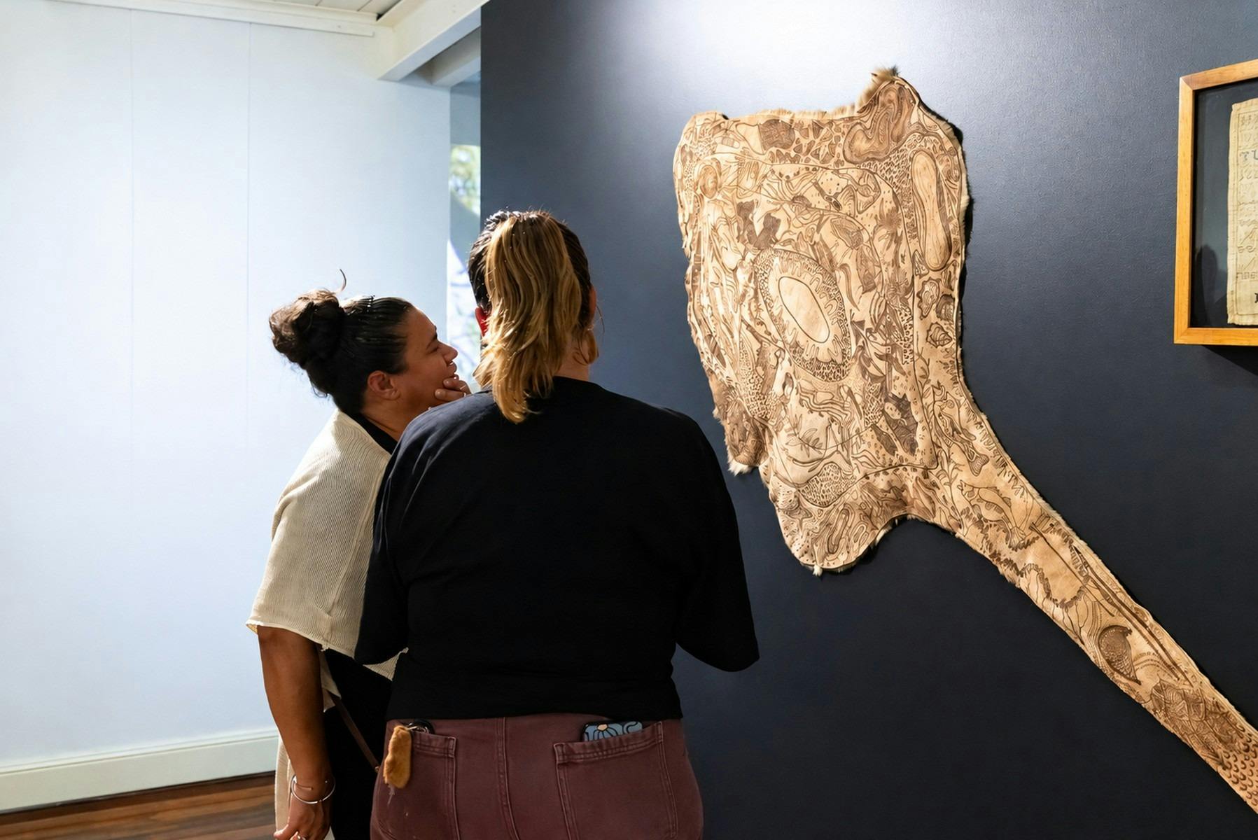 women viewing kangaroo skin artwork