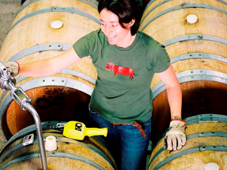 Lady tapping the wine barrel