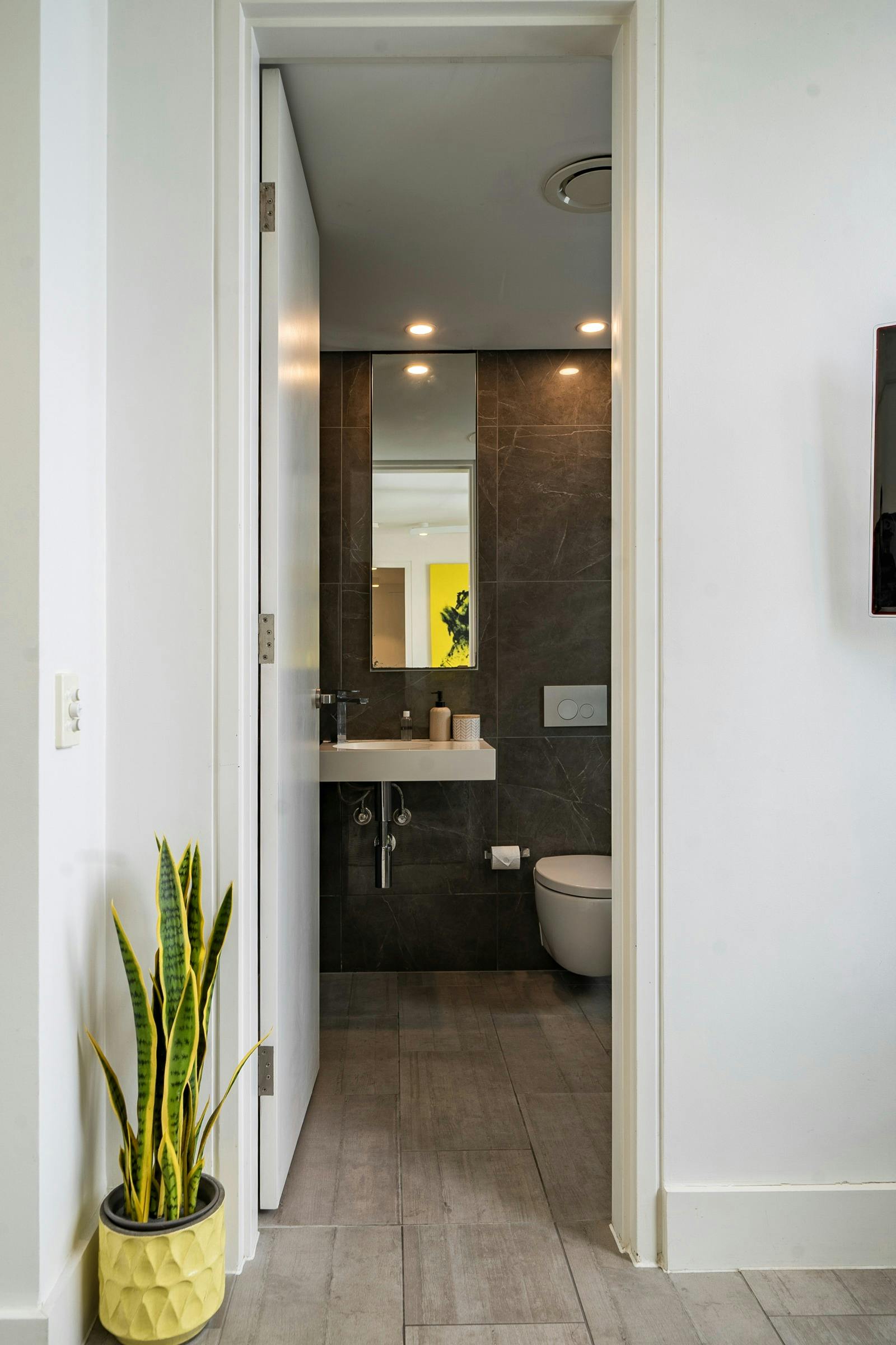 Sleek bathroom with glass shower, and a well-equipped laundry area with washing machine.