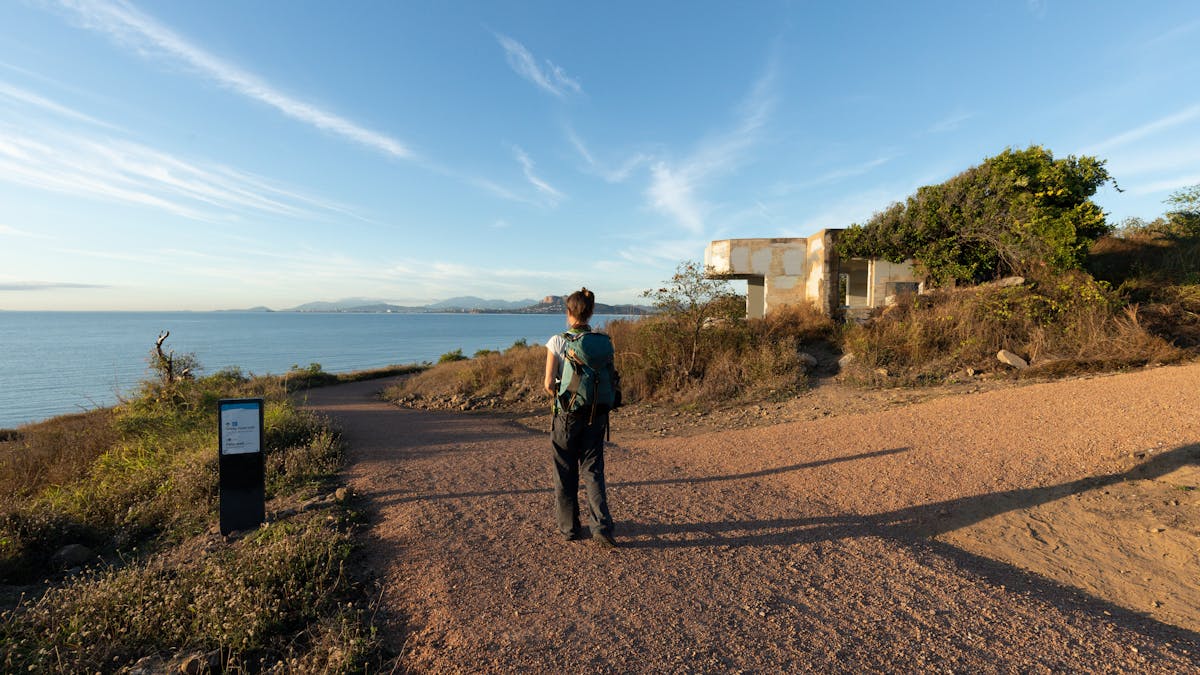 Person walking along a trail to an old fortification looking over the ocean. Person walking along a trail to an old fortification looking over the ocean.