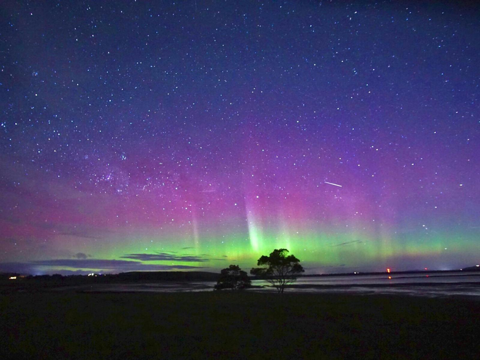 Aurora glowing above Iron Creek Bay Estate on a clear Tasmanian night.