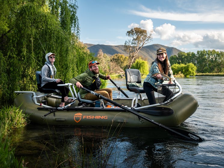 Fly fishing for trout on a drift boat on the the Tumut river in the Snowy Mountains