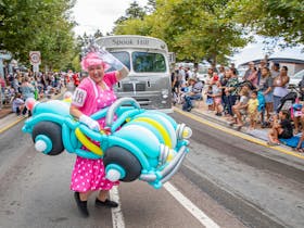 Girl in bright pink with a balloon car