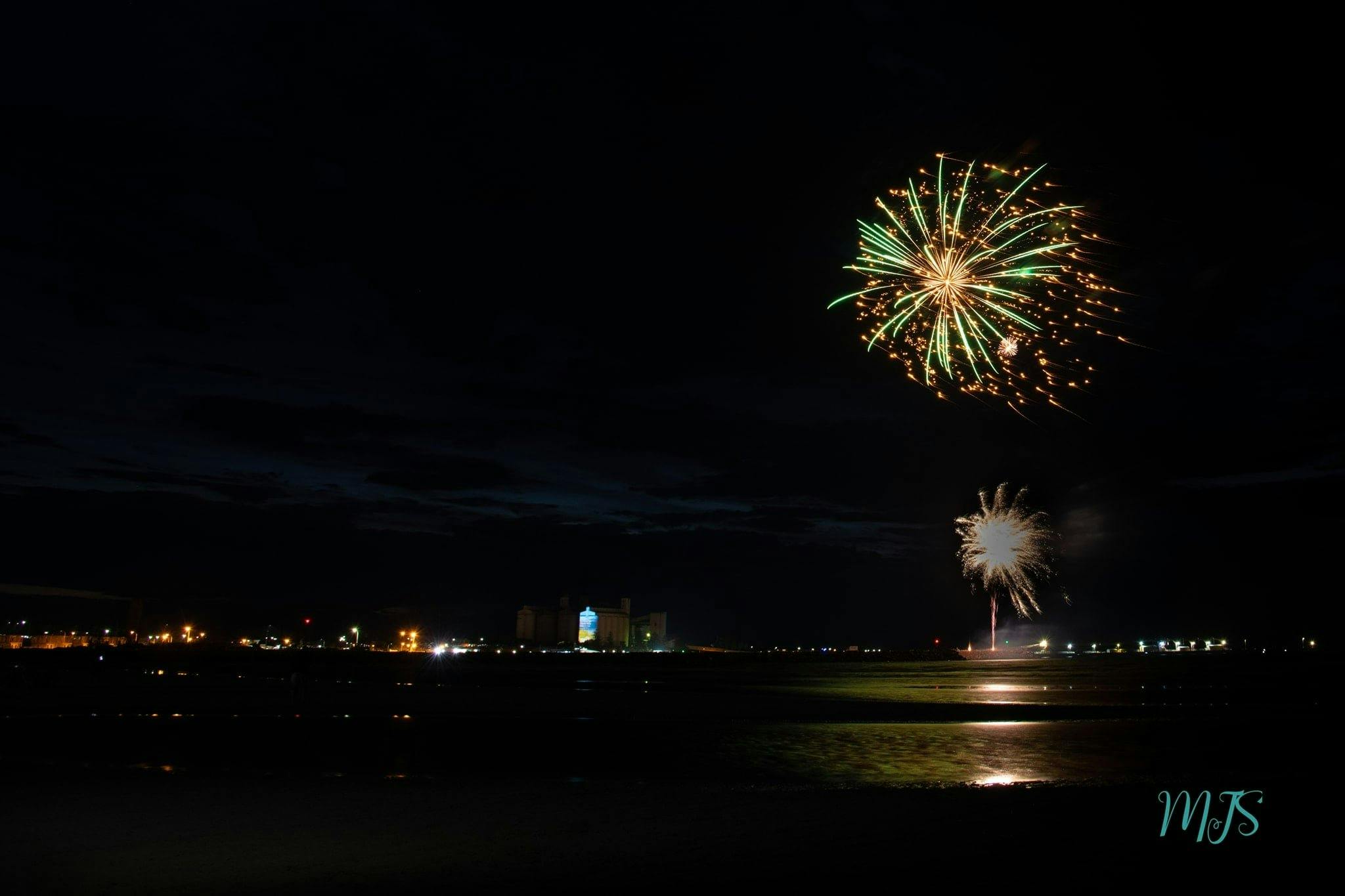 A green and golden firework in the night sky