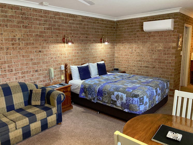 Image of our Deluxe Queen bedroom with lounge and desk