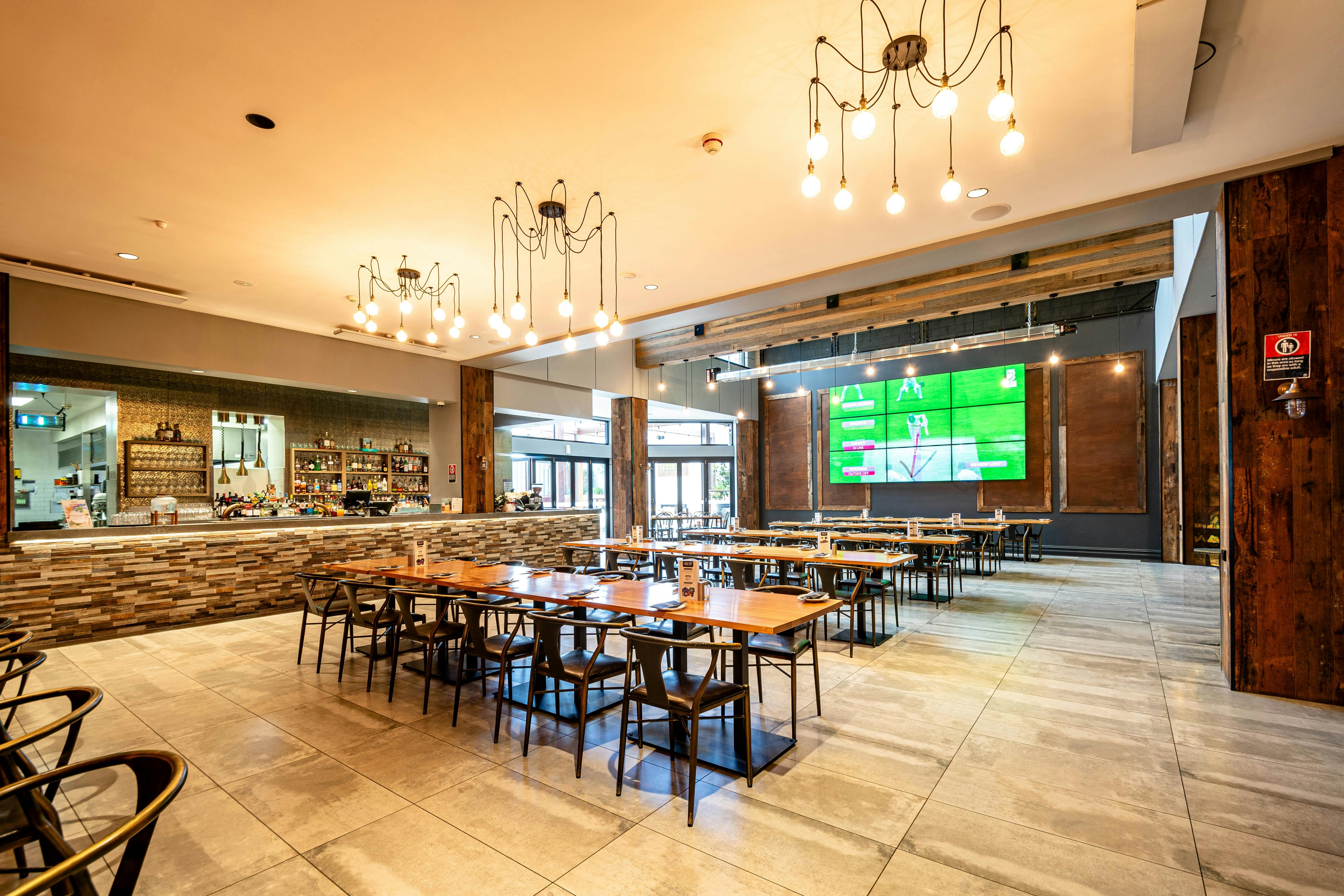 Interior image of The BHP Bistro, showing the dining area, bistro bar and large tv screen