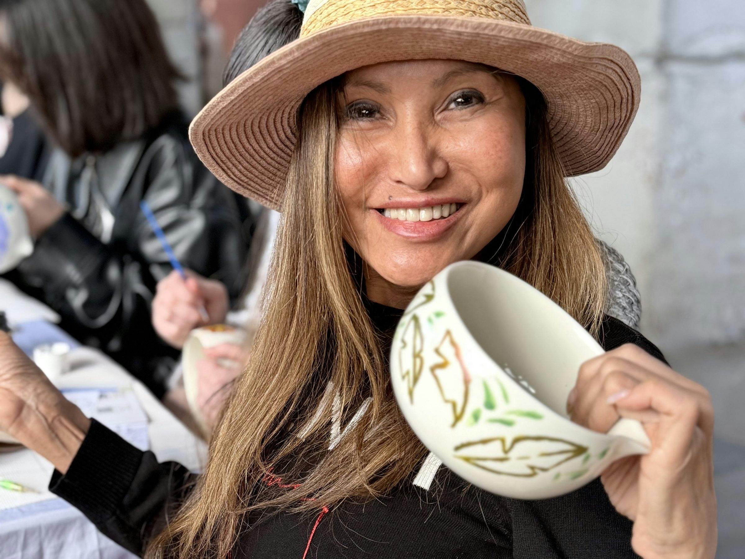 Guests holding their hand-painted ceramics at a NOA Matcha workshop