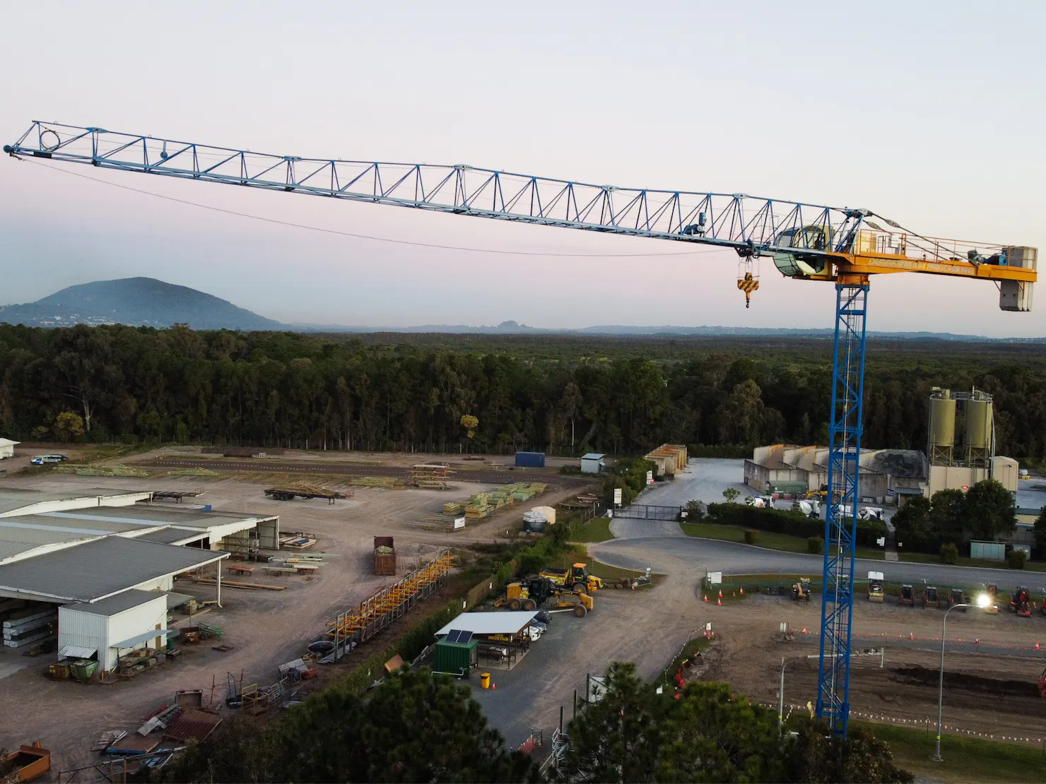 A large tower crane sits above the sunshine coast skyline