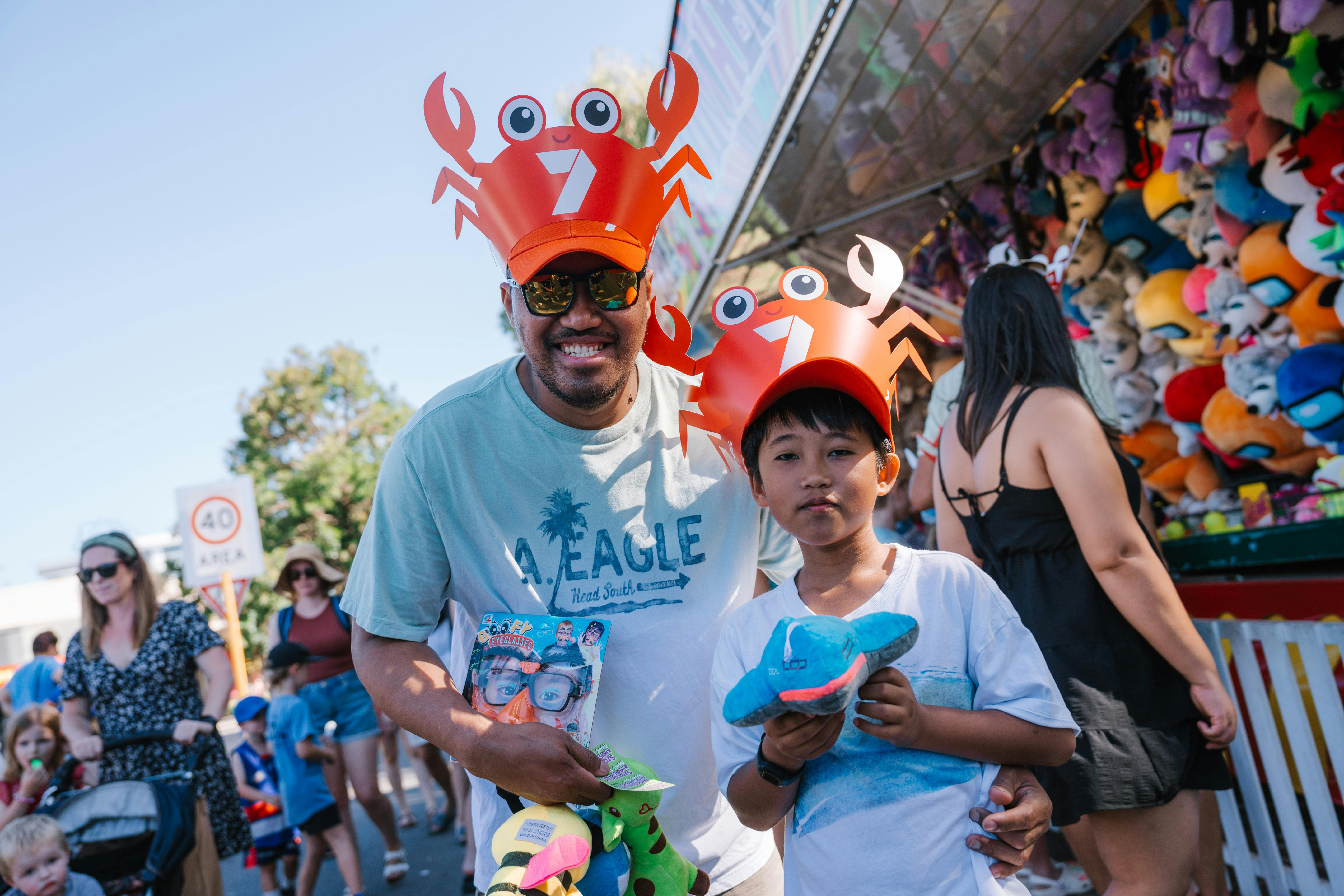 Father and son wearing matching crab hats at crab fest event