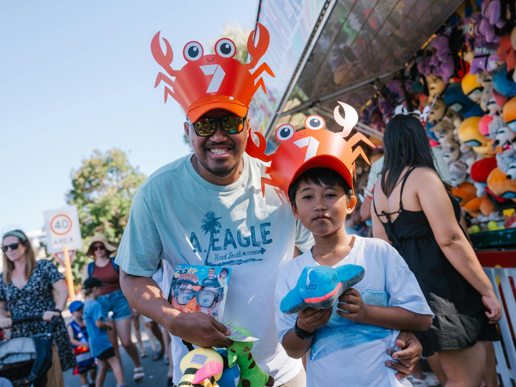 Father and son wearing matching crab hats at crab fest event