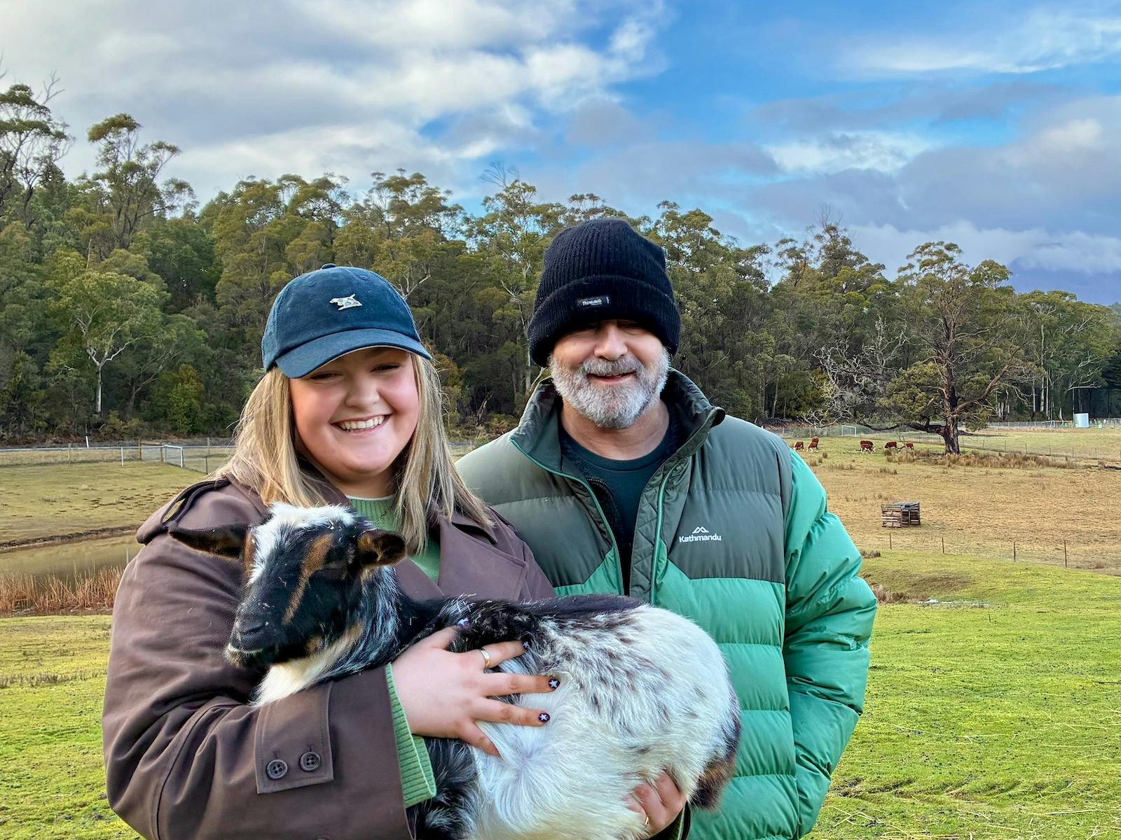 Father and Daughter holding a baby goat