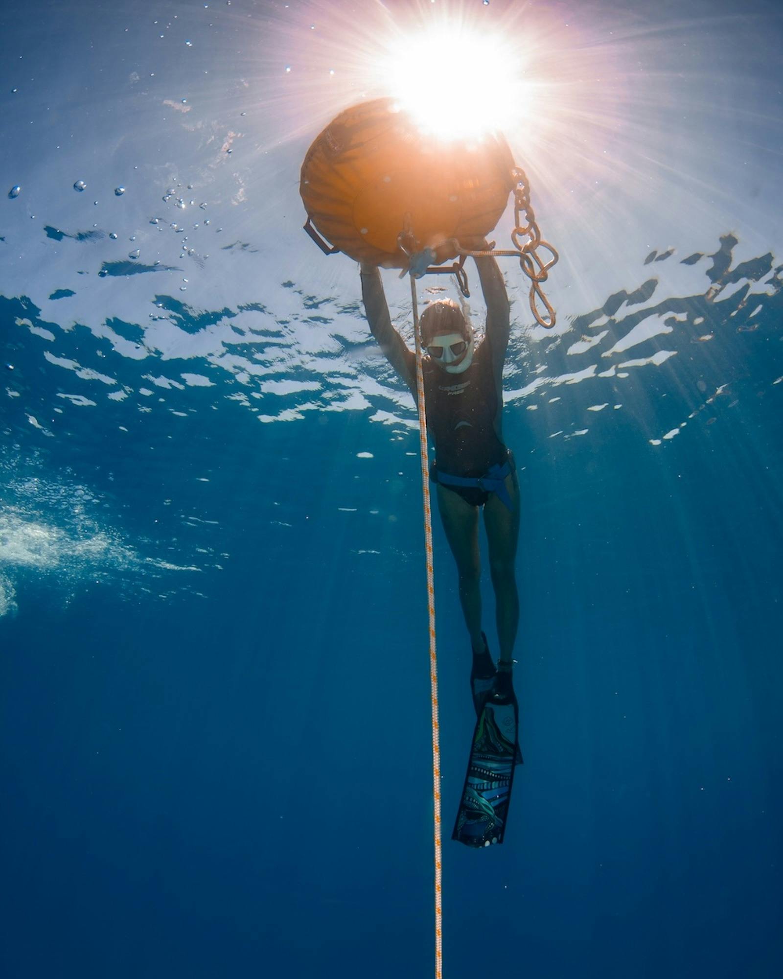 Freediver laying on the surface of the ocean surrounded by clear blue waters