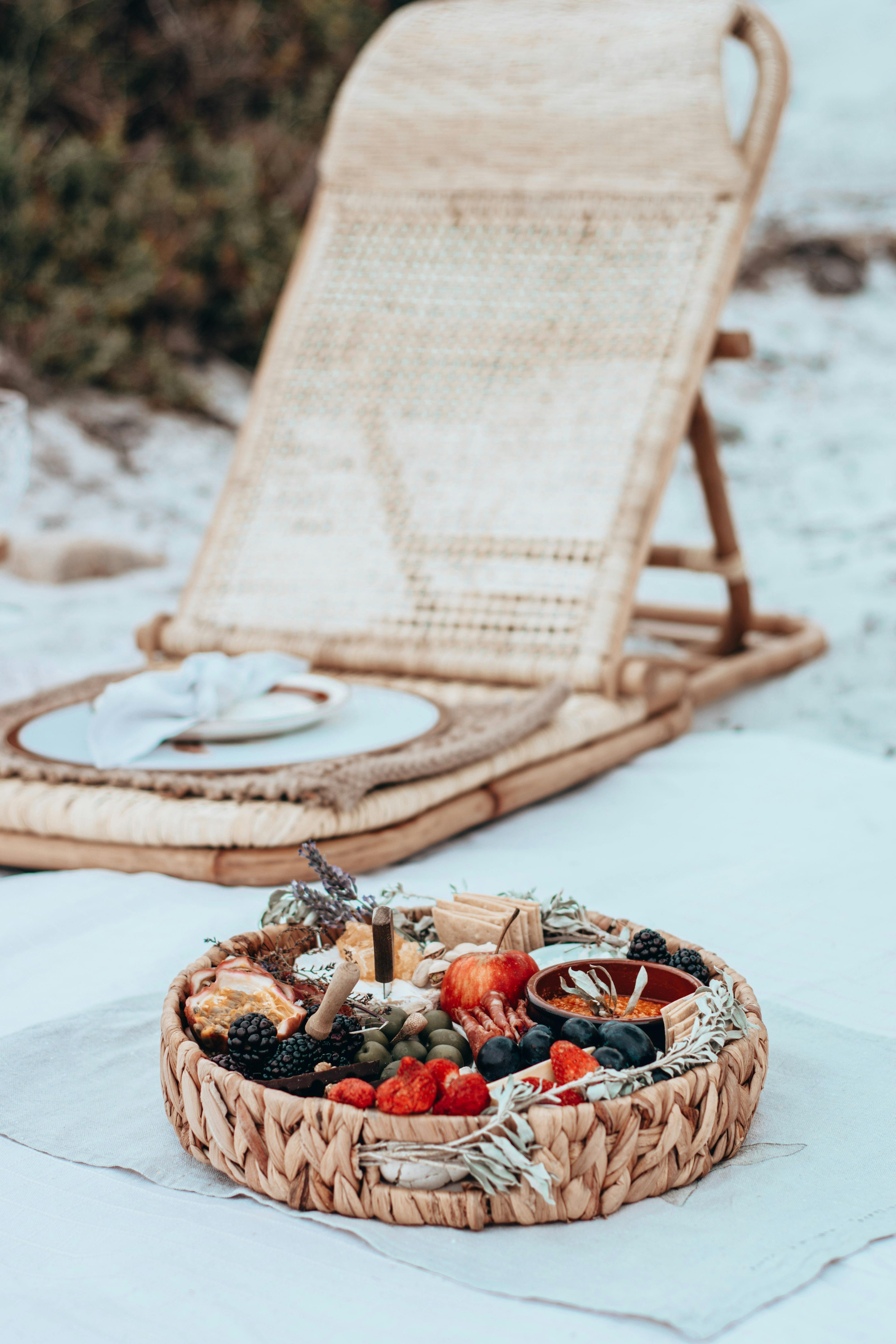 Beach picnic with wicker chair and gourmet platter